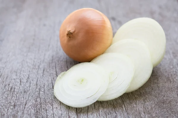 Cebola de close-up fatiada em fundo de madeira, conceito de ingrediente alimentar, foco seletivo — Fotografia de Stock