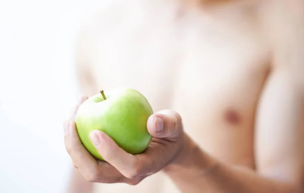 Gros plan main d'homme tenant pomme verte avec muscle sur fond blanc, soins de santé et concept médical, foyer sélectif Images De Stock Libres De Droits