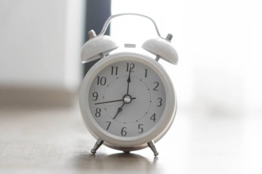 Gri arka planlı ahşap masa üzerinde çalar saat, seçici