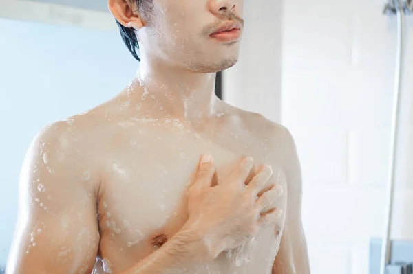 Closeup bonito asiático homem tomando um banho no banheiro, foco seletivo — Fotografia de Stock