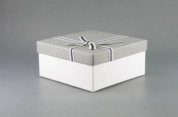 Caixa de presente cinza com fita em fundo cinza, espaço de cópia — Fotografia de Stock