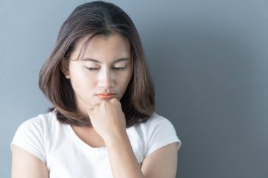 Yatak odasında yatakta oturan, düşünceli ya da depresif, seçici odaklı bir kadın.