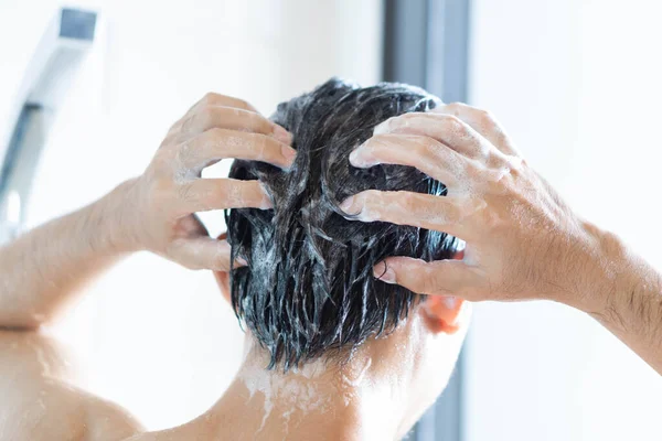 Vértes fiatalember mosás haját a samponnal a fürdőszobában, Vintage Tone, szelektív fókusz — Stock Fotó