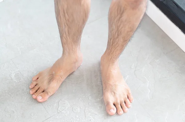 Cerrar las piernas del hombre con tomar una ducha en el baño, cuidado de la salud y la belleza — Foto de Stock