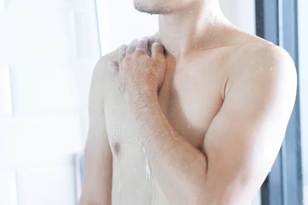 Primer plano guapo asiático hombre tomando una ducha en el baño, enfoque selectivo —  Fotos de Stock