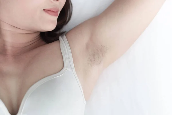 Γυναίκες πρόβλημα μαύρη μασχάλη που βρίσκεται σε λευκό κρεβάτι φόντο για την περιποίηση του δέρματος και την αίσθηση της ομορφιάς, επιλεκτική εστίαση — Φωτογραφία Αρχείου