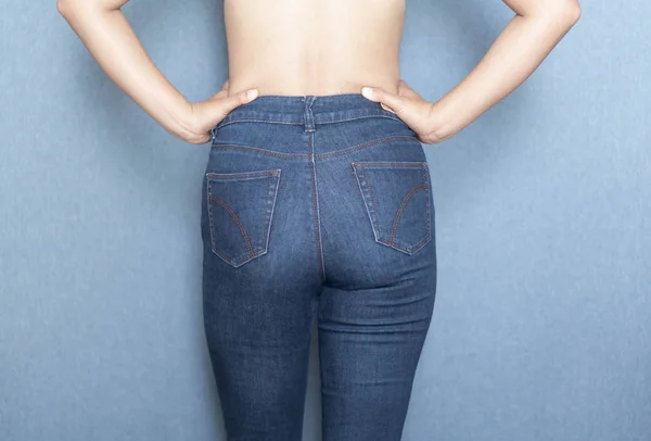 Mulher mostrando de volta de calças jeans e sexy inferior — Fotografia de Stock