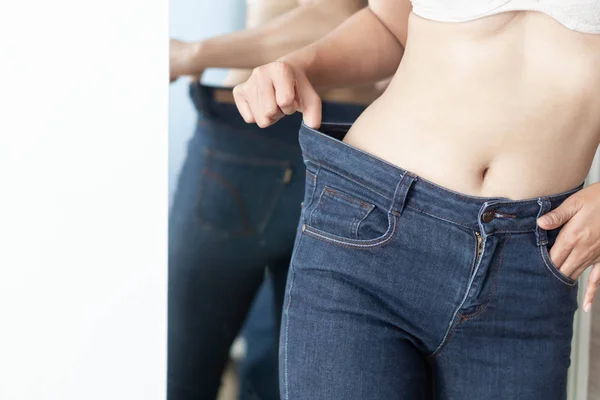 Mujer mostrando pantalones vaqueros y el cuerpo después de la pérdida de peso y sexy bo — Foto de Stock