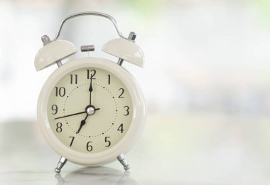 Beyaz masadaki çalar saat, sabah yumuşak ışıkla, seçici.