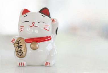 Şanslı kedi Maneki Neko masadaki zenginlik anlamına gelen metni göster, odaklanmayı seç