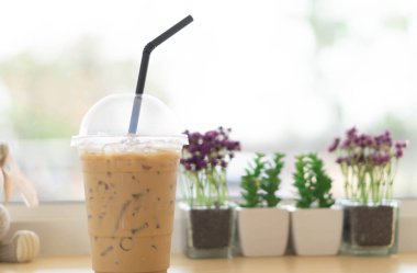 Kahve dükkanında bir bardak buzlu kahve ve saksı.