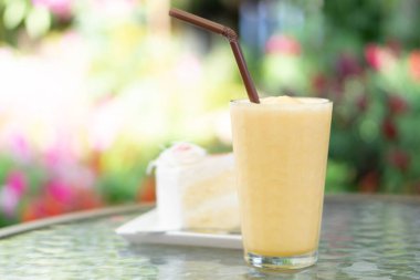 Yakından tutku meyveli smoothie yeşil doğa arka planı, seçici odaklı