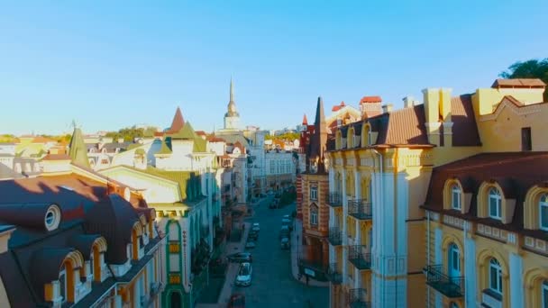 Cámara de drones se mueve al nivel de las azoteas de los edificios en las calles europeas estrechas antiguas con casas coloridas y peatones al atardecer, filmado en 4K UHD — Vídeos de Stock