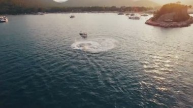 Jet Ski havadan görünümü ile bir koyda Depp mavi su ile gidiyor. Denizde, günbatımı vurdu içinde 4 k Uhd