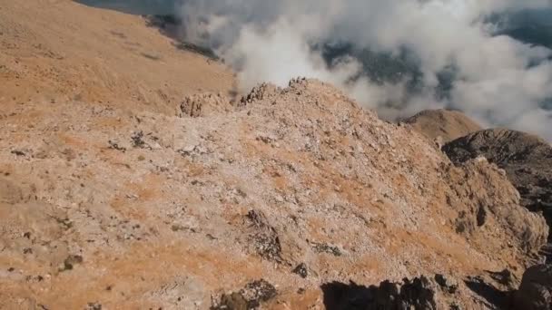 Volando a través de las suaves nubes esponjosas a gran altitud en las montañas en un día soleado, filmado en 4K UHD — Vídeo de stock