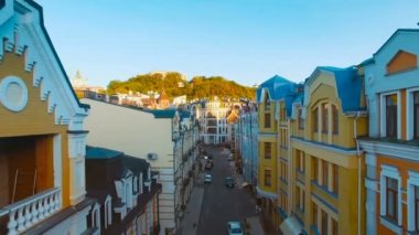 Günbatımında, sokaklarda eski dar Avrupa renkli evleri ve yayalar ile binaların çatıları düzeyinde hamle dron kamera 4 k Uhd vurdu