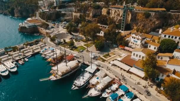 Vista aérea del puerto viejo donde muchos barcos, barcos y yates permanecen, los turistas caminan alrededor. Día soleado, Mar Mediterráneo, Disparo en 4K UHD — Vídeos de Stock