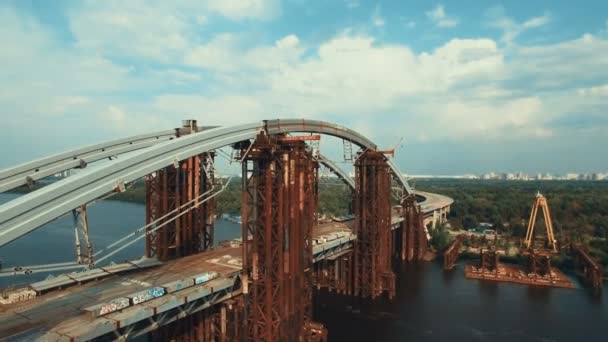 Вид с воздуха на массивный мост через реку, соединяющий два берега. the Road is under construction, Shot in 4K UHD — стоковое видео