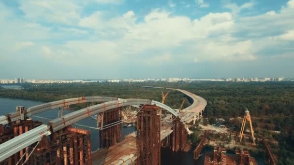 Вид с воздуха на массивный мост через реку, соединяющий два берега. the Road is under construction, Shot in 4K UHD — стоковое видео