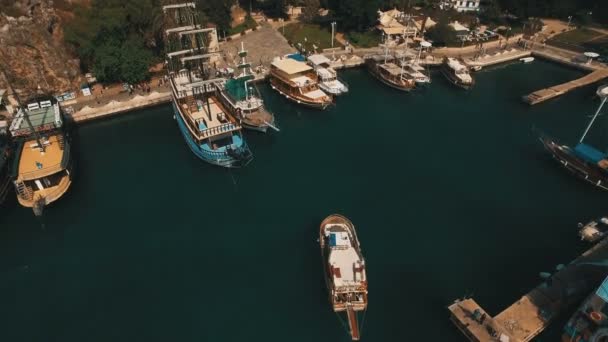 Vista aérea da natação e do barco de estacionamento em um porto velho, os turistas caminham ao redor. Dia ensolarado, tiro em 4K UHD — Vídeo de Stock