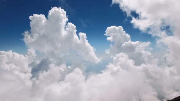 Vliegen door de zachte pluizige wolken op grote hoogte in de bergen op een zonnige dag, doodgeschoten in 4 k Uhd — Stockvideo