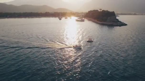 Vista aérea do barco de natação em uma baía com água azul de Depp. Pôr do sol no mar, tiro em 4K UHD — Vídeo de Stock