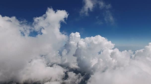Voler à travers les nuages doux et moelleux à haute altitude dans les montagnes par une journée ensoleillée, tourné en 4K UHD 