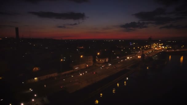 Вид с воздуха на европейский город ночью с подсветкой от автомобилей, набережная. Выстрел в 4K UHD — стоковое видео