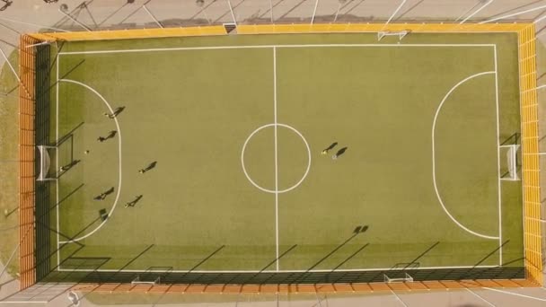 Над видом сверху дети играют в футбол на школьном стадионе аэродинамический 4K UHD — стоковое видео