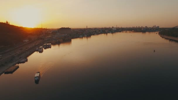 일몰에 유럽 리버 시티 근처 강을 따라 항해 하는 보트 — 비디오