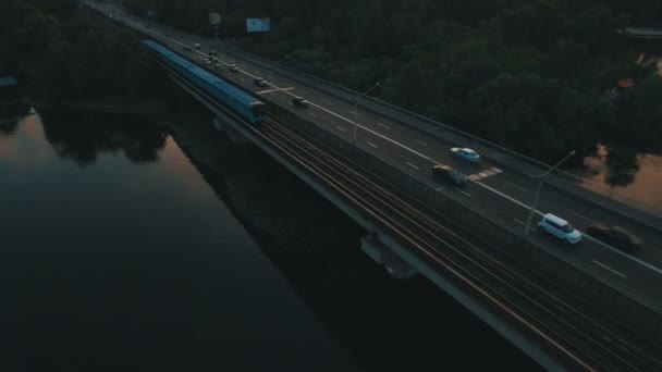 地铁和汽车的桥梁。在黄昏的空中无人机画面上的城市景观 — 图库视频影像