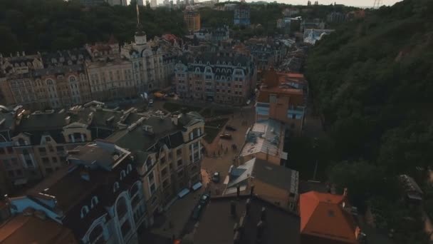 Drone met Camera beweegt onder daken van gebouwen op de oude Europese straatjes met kleurrijke huizen en voetgangers bij zonsondergang 4k — Stockvideo