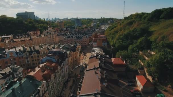 Câmera Drone se move sob telhados de edifícios nas ruas europeias estreitas antigas com casas coloridas e pedestres ao pôr do sol 4K — Vídeo de Stock