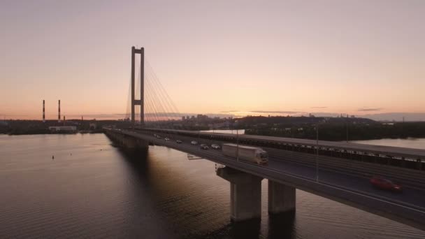 Brug met trafic over de rivier bij zonsondergang luchtfoto drone-beelden — Stockvideo