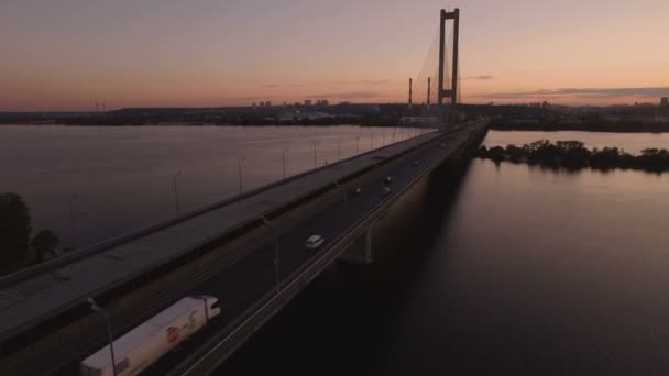 Мост с трафиком над рекой на съемках беспилотника на закате — стоковое видео
