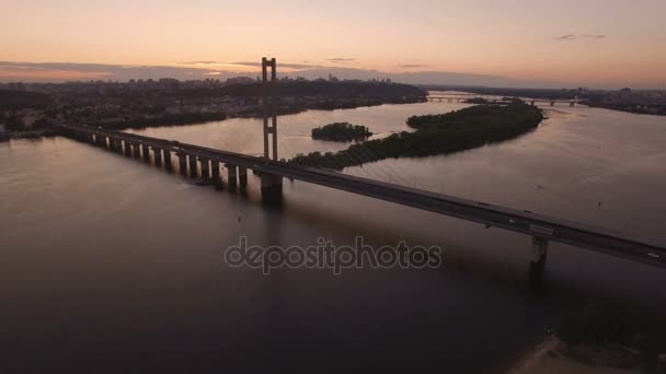 Bro med trafic över floden vid solnedgången antenn drönare footage — Stockvideo