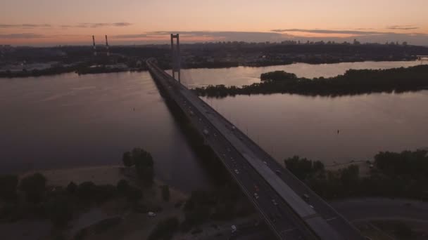 Brug met trafic over de rivier bij zonsondergang luchtfoto drone-beelden — Stockvideo