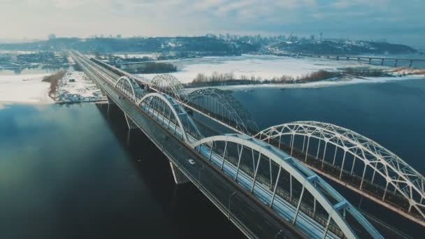 Carros e trem se move em uma ponte sobre um rio congelado drone aéreo metragem — Vídeo de Stock