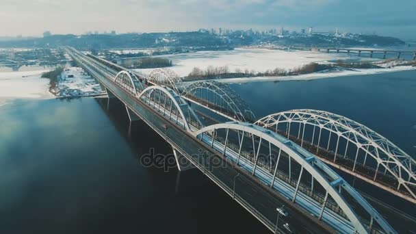 車や鉄道は冷凍川空中ドローン映像上に橋の上に移動します。 — ストック動画