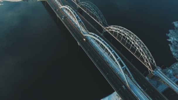 Cars and train moves on a bridge over a frozen river aerial drone footage — Stock Video