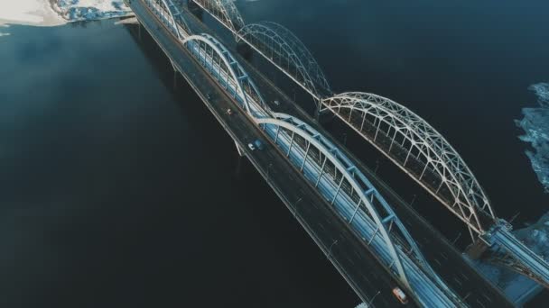 Carros e trem se move em uma ponte sobre um rio congelado drone aéreo metragem — Vídeo de Stock