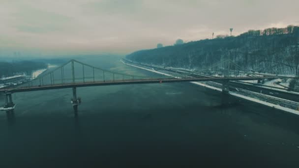 Brug over de stad. Voetgangersbrug in de mistige winterdag. Luchtfoto drone-beelden — Stockvideo