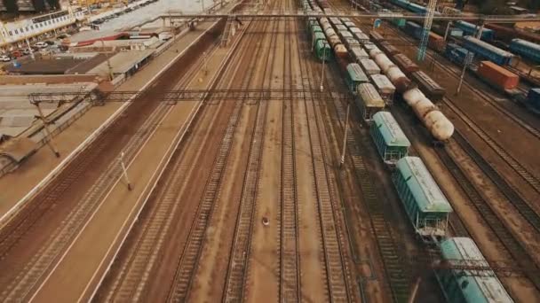Patio ferroviario con muchas líneas ferroviarias y trenes de mercancías. Antena — Vídeo de stock