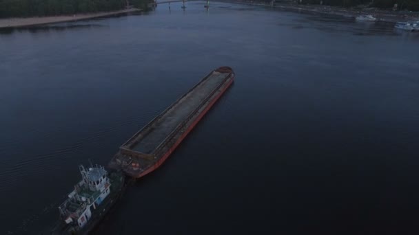 Barcaza navega a lo largo del río cerca del puerto de la ciudad en el atardecer imágenes aéreas — Vídeos de Stock