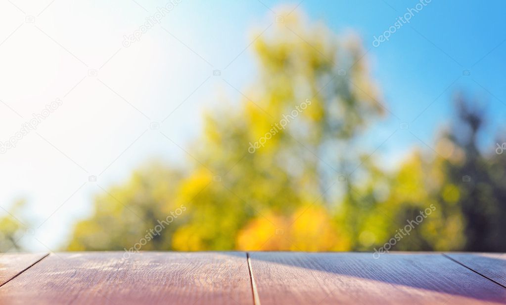 Wood table top on colorful blurred abstract outdoor background