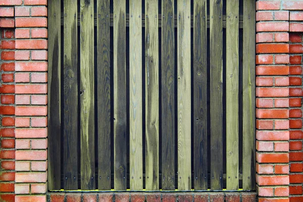 Valla de ladrillo rojo con tablones de madera verticales —  Fotos de Stock