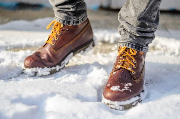 Человек ходит по снегу. Ноги в коричневых зимних сапогах. Зимние сапоги — стоковое фото
