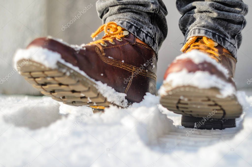 Brown leather shoes in the snow. Legs in the warmth concept