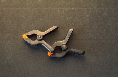 Siyah kelepçe siyah arka plan üzerine turuncu plastik jawson ile çifti