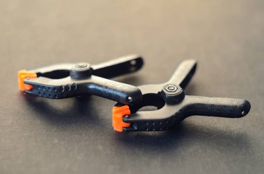 Siyah kelepçe siyah arka plan üzerine turuncu plastik jawson ile çifti